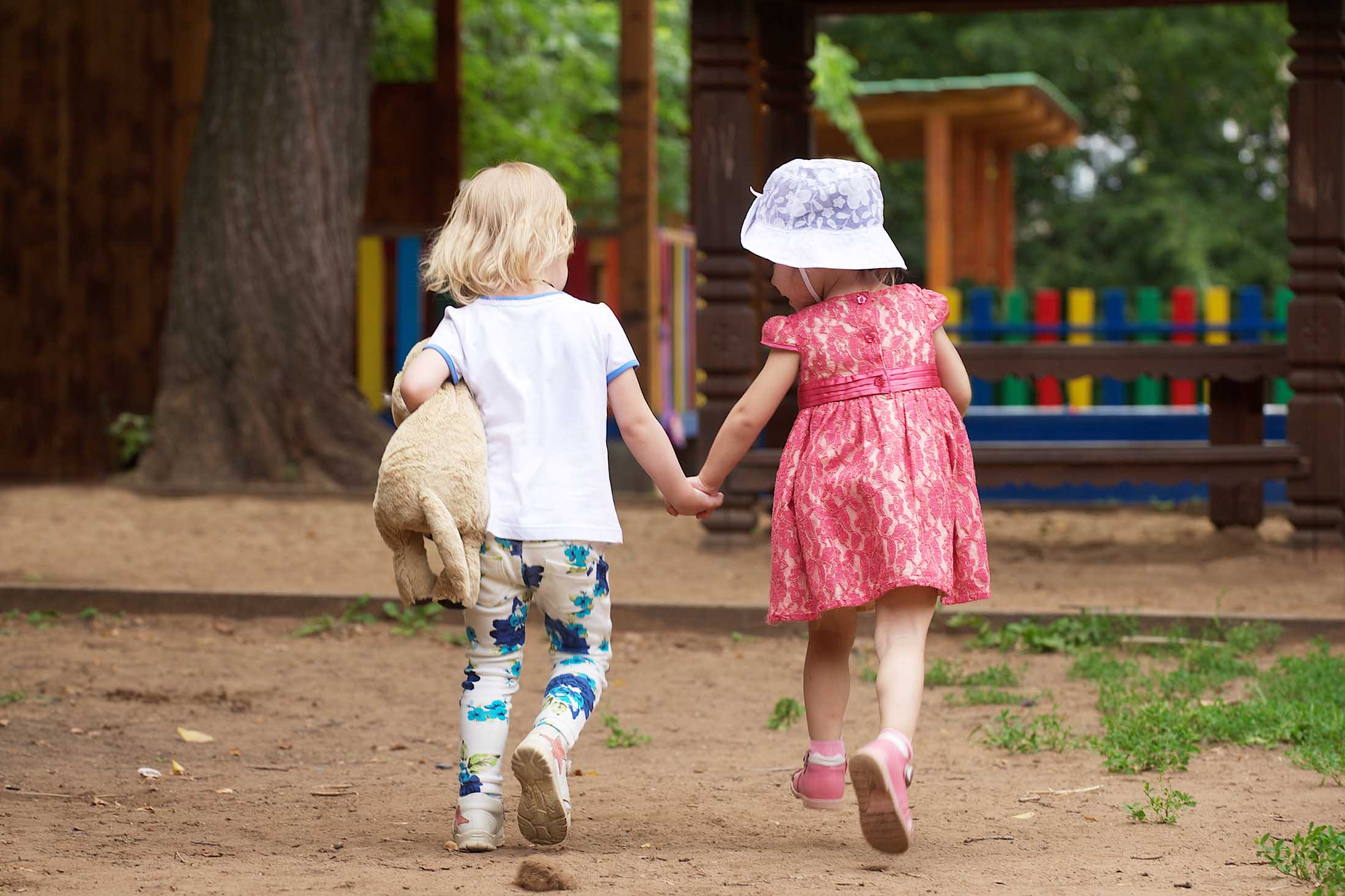 To barn som løper mot lekeplassen. Foto